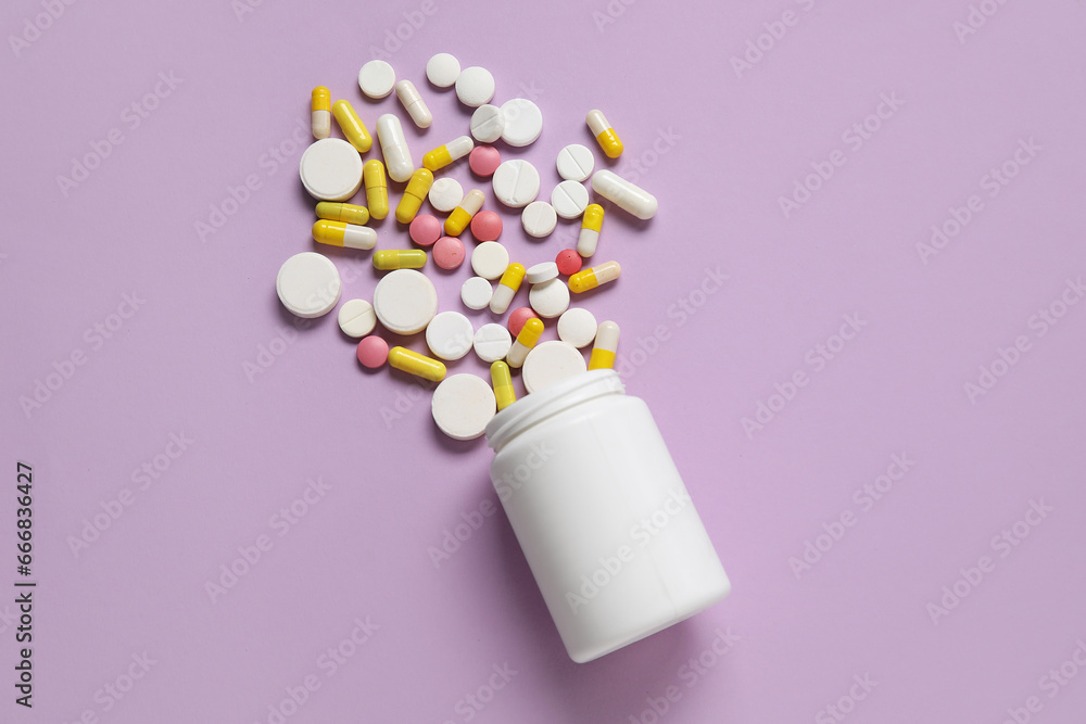 Jar with different scattered pills on lilac background