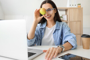 Poster - Pretty young female programmer with green apple in office