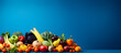 A colorful assortment of fruits and vegetables on a vibrant blue background with ample space for text or design elements,
