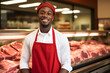 Young smiling black butcher standing at the meat counter