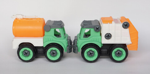 Wall Mural - Two DIY plastic truck toy isolated on white background. water truck and garbage truck.