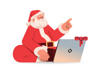 Wall Mural - santa claus in red costume sitting lotus pose, using laptop and pointing finger at something happy new year merry christmas holidays celebration