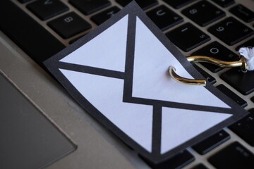Wall Mural - closeup image of mail with hook on top of keyboard. phishing email, malware and cyber security conce