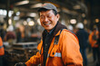 A happy male senior Asian worker in a factory