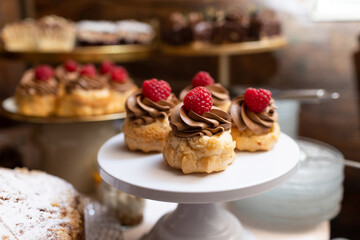 Raspberry dessert. Tray of fruit muffins. Bakery background. Chocolate cream cupcake. Wedding catering sweet table.