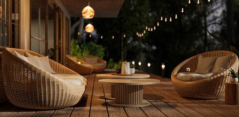 A beautiful deck with round wicker armchairs, outdoor string lights and a nature view at night.