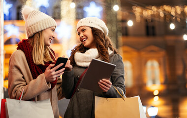 Wall Mural - Sale, shopping, tourism and happy people concept. Beautiful females with shopping bags in the city