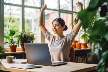 Wall Mural - Young adult woman sitting in home office at a table, stretching. Happy satisfied woman working from home in her home office, stretching.