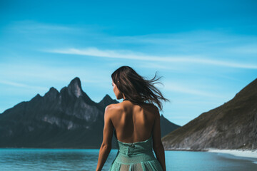 Wall Mural - distant view of Woman looking at a mountain and turquoise lagoon, diatnt view, aesthetic look