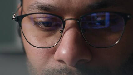 Close up businessman in eyeglasses working with computer data crypto analyzing cropped view male eyes in glasses looking at laptop monitor screen blue light reflection man business programming codding