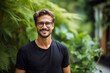 © alisaaa - Portrait of young handsome man with beard and glasses, Young man in black shirt smiling looking at camera, Outdoor nature background