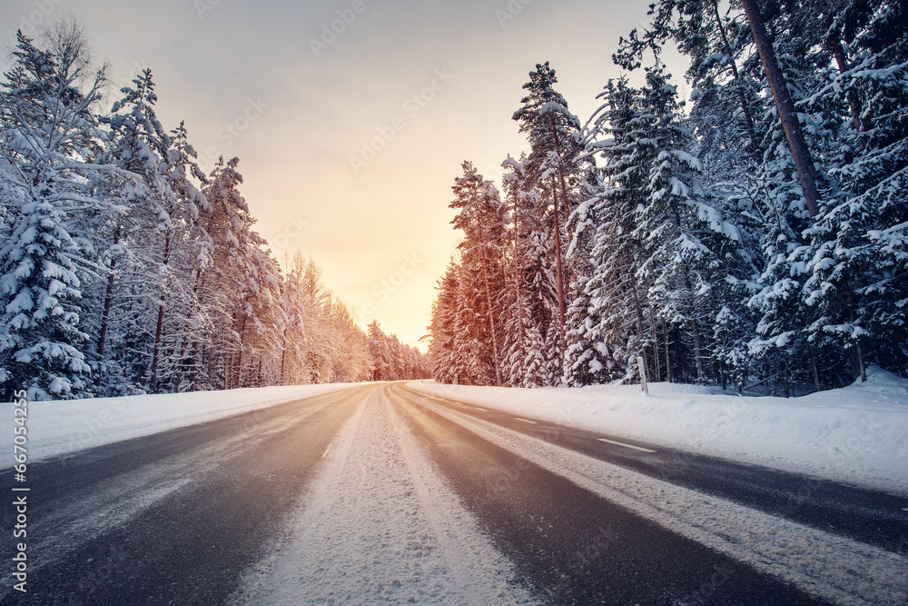 Beautiful view of the sunset in the evening on the country snowy road ...
