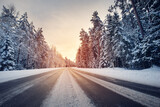 Fototapeta  - Beautiful view of the sunset in the evening on the country snowy road.