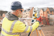 © Iryna - Surveyor builder site engineer with theodolite total station at construction site outdoors during surveying work