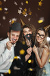 © blackday - Group of happy people wearing party hats and using funny photo booth props are celebrating a holiday or event