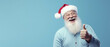 Portrait of santa claus showing a thumb up on light blue background
