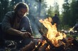 A man with long hair is cooking something over a campfire. This image can be used to depict outdoor cooking, camping, or wilderness survival