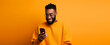 attractive african american man with phone against orange background. halloween,thanksgiving concept etc