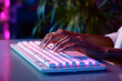 close up female hands typing on keyboard pc, working /chatting indoor environment, neon colors