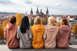 © Jasmina - Rear view of  five young women sitting together on rooftop and looking at city
