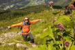 © Guzel - Top view of gray-haired long-haired male traveler with backpack among alpine slopes, Austria