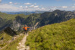 © Guzel - Man standing on rocky mountain path with arms spread wide, enjoying freedom, Austria