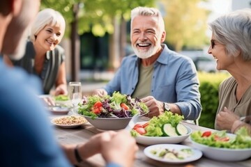 group diversity old senior people eating healthy salad after exercising in the park in tracksuit in 