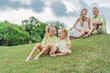 © galitskaya - A happy family, two girls, dad, and a pregnant mom, enjoys quality time together on a lush green lawn, creating cherished memories of togetherness