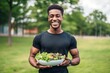 © A Denny Syahputra - African Young man eating healthy salad after exercising in the park in tracksuit in daytime