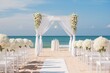 Beautiful beach wedding decor with white decorated chairs and reception stage