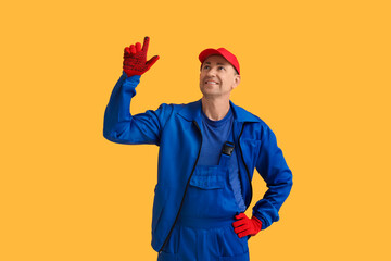 Sticker - Portrait of male mechanic pointing up on orange background