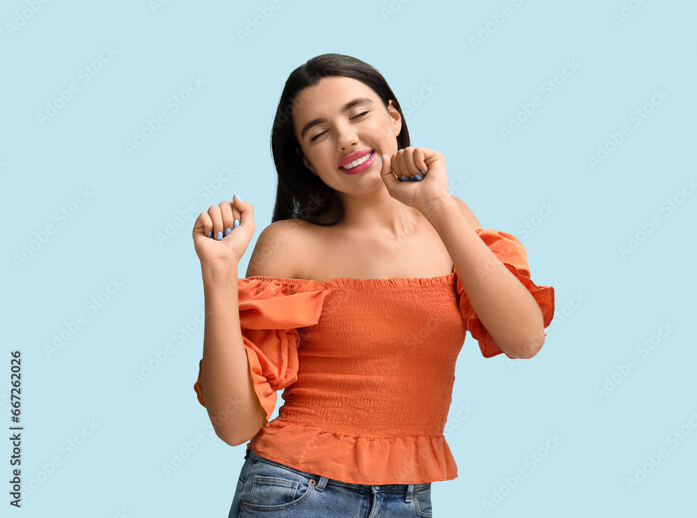 Beautiful young happy woman on blue background