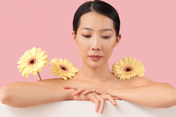 Poster - Beautiful Asian woman with flowers on pink background, closeup