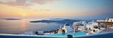Fototapeta  - A rooftop in Santorini, Greece, white buildings with blue domes, overlooking the sea, sundown colors
