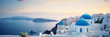 Fototapeta  - A rooftop in Santorini, Greece, white buildings with blue domes, overlooking the sea, sundown colors