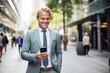 © blvdone - Businessman walking street using smartphone
