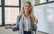 © piai - A woman wearing a formal outfit pointing at a whiteboard