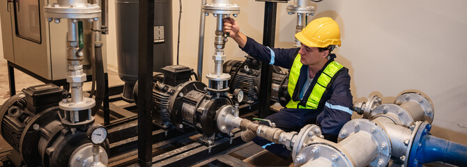 Engineers inspecting the inside plumbing and water valves of an industrial facility.