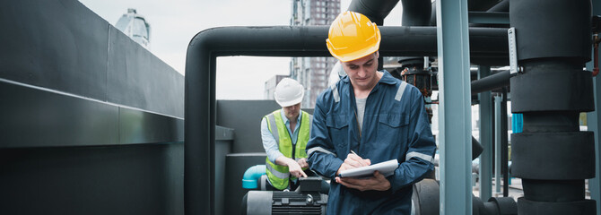 Engineer and team examining the air conditioning cooling system of a huge building or industrial site.