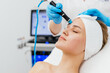 © Vladislav - Close-up shot of a young beautiful woman lying on a couch in a cosmetology center. Young woman doing hydrofacial therapy in beauty spa.
