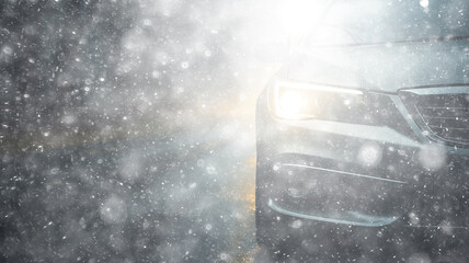 Poster - snowfall, car, background in a snowstorm with a copy of the space, the headlights of an oncoming car through a thick snowfall, winter view on the highway, headlight light