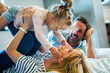 © NDABCREATIVITY - Young family being playful at home. People parent child fun happiness concept.