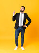 © luismolinero - Full-length shot of business man over isolated yellow background with fingers crossing and wishing the best