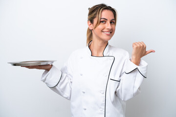 Canvas Print - Young chef woman with tray isolated on white background pointing to the side to present a product