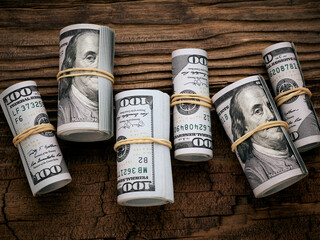 Wall Mural - 100 dollars cash rolls over vintage wooden background