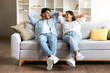 © Prostock-studio - Cheerful Indian couple enjoying a moment on a couch in a cozy living room