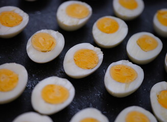 Wall Mural - Many halves of boiled chicken eggs lying on table closeup background. Healthy eating concept