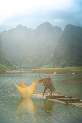 Wall Mural - view of fishermen fishing on river in Thung mountain in Tra Linh, Cao Bang province, Vietnam with lake, cloudy, nature