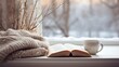 A cup of coffee and an open book on the windowsill and a winter view in the window. cozy homely atmosphere