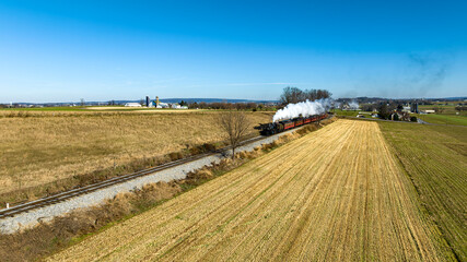 Canvas Print - An Aerial View of a Steam Passenger Train Approaching, Traveling thru Farmlands Blowing Smoke on a Fall Day
